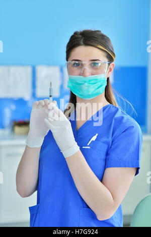 Le chirurgien dentiste dans mask holding seringue pour l'injection de l'anesthésie. Banque D'Images