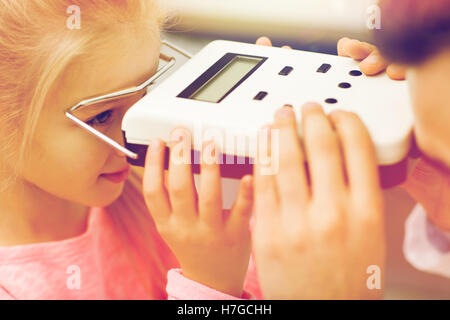 Opticien avec pupillometer et fille à eye clinic Banque D'Images