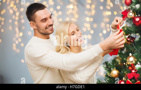 Heureux couple decorating Christmas Tree Banque D'Images