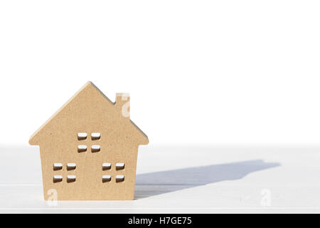 Jouet en bois maison et mot sur table, sur fond blanc Banque D'Images