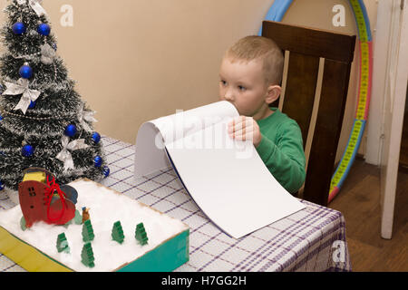 Boy écrit une lettre au Père Noël qui lui a apporté des cadeaux Banque D'Images