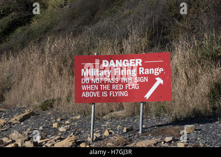Les panneaux d'avertissement et de drapeaux rouges à Kimmeridge Bay, Dorset Banque D'Images