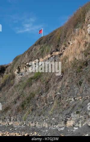 Les panneaux d'avertissement et de drapeaux rouges à Kimmeridge Bay, Dorset Banque D'Images