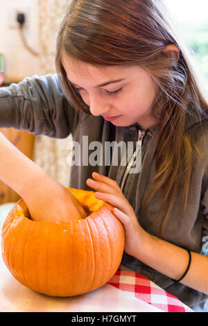 Jeune fille sculpter une citrouille à l'Halloween modèle libération : Oui. Biens : Non. Banque D'Images