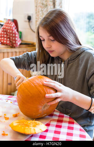 Jeune fille sculpter une citrouille à l'Halloween modèle libération : Oui. Biens : Non. Banque D'Images