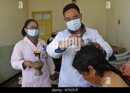 Ngamring, la Région autonome du Tibet. 29Th sep 2016. Un médecin soigne un patient avec compresse chaude thérapie dans l'hôpital, en tibétain Ngamring Ngamring Comté, sud-ouest de la Chine, région autonome du Tibet, le 3 novembre 2016. La médecine tibétaine a absorbé les influences de chinois traditionnel, et d'Indiens de la médecine arabe et est surtout pratiqué au Tibet et dans la région de l'Himalaya. Il utilise des herbes, des minéraux et des insectes et parfois des parties d'animaux. © Liu Dongjun/Xinhua/Alamy Live News Banque D'Images