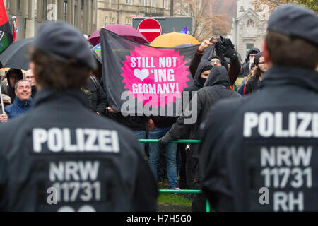 Les manifestants de gauche à un rassemblement à Bielefeld, Allemagne tenir une inscription en anglais disant "ne pas aimer l'Allemagne' en face d'agents de police Banque D'Images