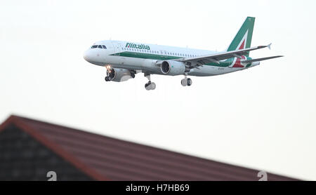 Un avion d'Alitalia décolle de l'aéroport d'Heathrow au coucher du soleil. Banque D'Images