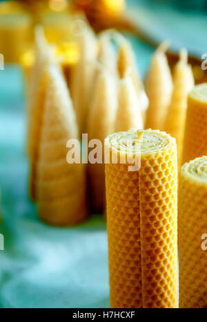 La belle main fait des bougies de cire d'abeilles de formes différentes. Banque D'Images