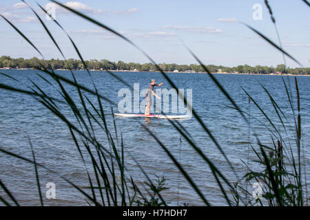 Adolescent paddleboarding sur un lac non loin du rivage. Clitherall Minnesota MN USA Banque D'Images