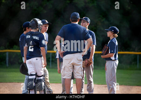 Entraîneur de baseball ayant une conversation avec lanceur de l'adolescence à la motte au dans l'équipe de consultation. St Paul Minnesota MN USA Banque D'Images