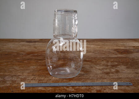 Carafe en verre gravé fantaisie et sur une surface en bois avec une règle en métal Banque D'Images