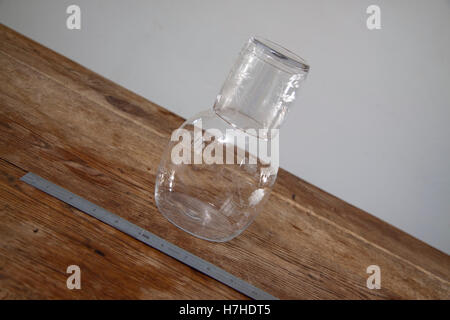 Carafe en verre gravé fantaisie et sur une surface en bois avec une règle en métal Banque D'Images