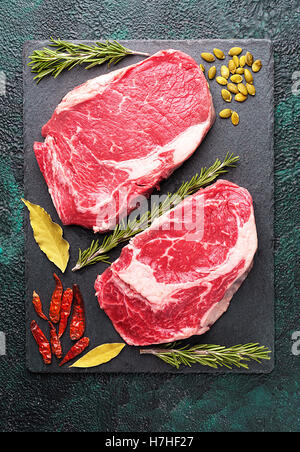 Deux morceaux de boeuf de la viande sur une plaque en ardoise avec Rosemary Banque D'Images