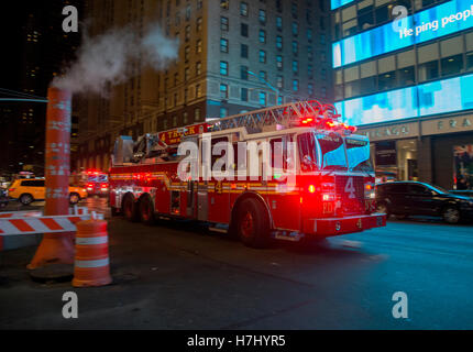 New York fire truck se précipite au-delà d'un évent à vapeur sur la 7e Avenue Banque D'Images