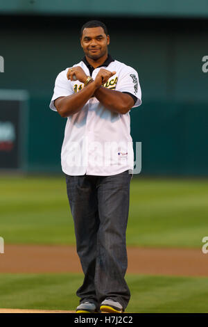 13 septembre, 2011 ; Oakland, CA, USA ; Oakland Raiders attaquer défensif Richard Seymour se dresse sur la pitchers mound avant de jeter la première cérémonie terrain avant le match entre les Athletics d'Oakland et Los Angeles Angels à O.co Coliseum. Banque D'Images
