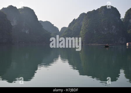 Montagnes et voile à l'intérieur d'un village flottant dans la baie d'Halong, Vietnam Banque D'Images
