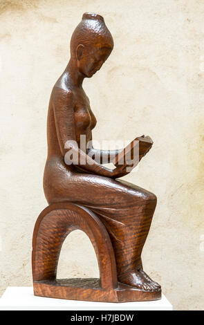 Le lecteur, femme lisant un livre, sculpture en acajou du sculpteur français Jean Henninger Banque D'Images