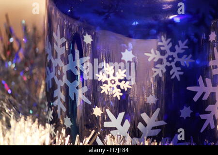 En verre bleu cobalt et les flocons d'argent au repos dans Garland avec la lumière qui se reflète sur la guirlande d'argent,close up de la lumière qui se reflète sur le verre cobalt Banque D'Images