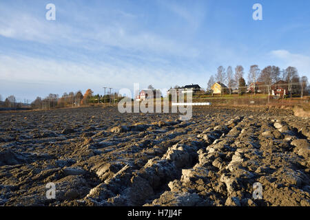 Labouré congelés pré et un petit village de l'arrière-plan, photo du nord de la Suède. Banque D'Images