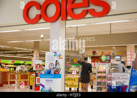 Femme à l'entrée du supermarché Coles à Warriewood Sydney, Nouvelle-Galles du Sud, Australie Banque D'Images