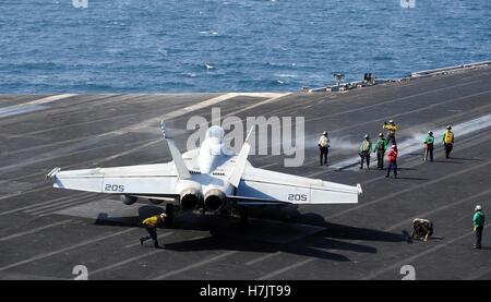 Des soldats américains signal à un F/A-18F Super Hornet, l'atterrissage d'un aéronef à bord du poste de pilotage de la marine américaine de classe Nimitz porte-avions USS George H. W. Octobre 13, 2014 Bush dans le golfe Arabo-Persique. Banque D'Images