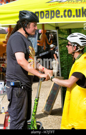 Jeune homme tente de monter un stand up 2 roues scooter électrique pour la première fois, Fête de la musique, Jimmy's Farm, Ipswich, Royaume-Uni Banque D'Images