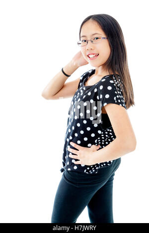 Tween asiatique fille trouver une pose assurée, isolé sur fond blanc Banque D'Images