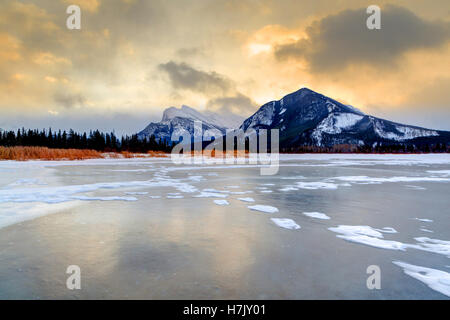 Frozen Vermilion Lake dans le parc national de Banff avec Mt. Rundle en arrière-plan. Un ciel couvert, froid matin juste avant le lever du soleil. Banque D'Images