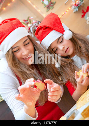 Portrait d'une mère aimante enseigner sa petite fille pour faire des desserts, la cuisson du pain d'épices et les biscuits de Noël Banque D'Images