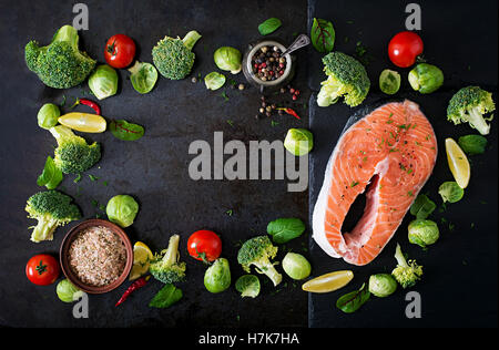 Pavé de saumon cru et ingrédients pour la cuisson sur un fond sombre dans un style rustique. Vue d'en haut Banque D'Images