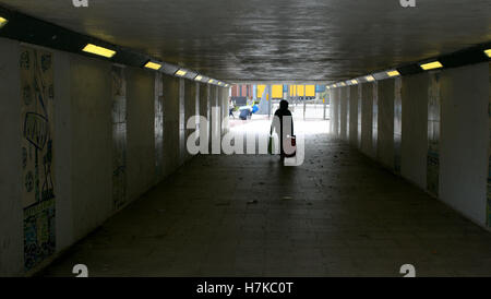 Femme marche i avec chariot n ville silhouette passage inférieur de Glasgow, Écosse, Royaume-Uni Banque D'Images