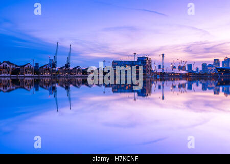 Royal Victoria Dock à Londres au coucher du soleil avec la ville illuminée y compris Canary Wharf Banque D'Images