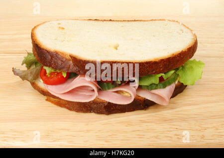 Sandwich à la salade de jambon coupé épais sur une planche à découper en bois Banque D'Images