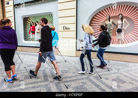 Des jeunes faisant de la marche nordique dans la rue Parizska, en passant par Dior boutique de luxe, Vieille Ville, République Tchèque Banque D'Images