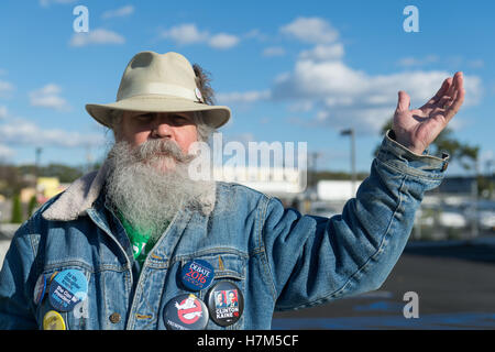 23 octobre 2016 - Merrick, New York, United States - Fred S. CHANDLER, 66 ans, de North Bellmore, portant plusieurs boutons campagne politique soutenant le candidat démocrate Hillary Clinton, des gestes avec la main pendant s'unissent pour réclamer l'eau publique et l'arrêt New York American Water (NYAW) hausse des taux. Veste en jean à boutons étaient pour l'Université de Hofstra Débat 2016 - et ''So Ma fille sait qu'elle peut être président. Hillary 16'' - ''TRUMPBUSTERS'' - ''CLINTON KAINE 16'' - et l'homme avec un caractère de monopole ''ATOUT JAMAIS'' du texte. (Crédit Image : © Ann Parry via Zuma sur le fil) Banque D'Images