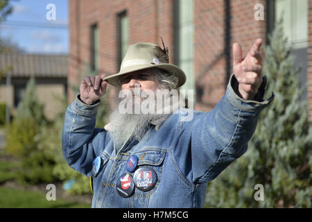 23 octobre 2016 - Merrick, New York, United States - Fred S. CHANDLER, 66 ans, de North Bellmore, portant plusieurs boutons campagne politique soutenant le candidat démocrate Hillary Clinton, des gestes avec la main tout en parlant au cours de s'unissent pour réclamer l'eau publique et l'arrêt New York American Water (NYAW) hausse des taux. Veste en jean à boutons inclus pour l'Université de Hofstra Débat 2016 - et ''So Ma fille sait qu'elle peut être président. Hillary 16'' - ''TRUMPBUSTERS'' - ''CLINTON KAINE 16'' - et l'homme avec un caractère de monopole ''ATOUT JAMAIS'' du texte. (Crédit Image : © Ann Parry via Zuma sur le fil) Banque D'Images