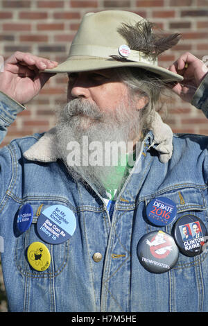 23 octobre 2016 - Merrick, New York, United States - Fred S. CHANDLER, 66 ans, de North Bellmore, portant plusieurs boutons campagne politique soutenant le candidat démocrate Hillary Clinton, l'accroche à son chapeau dans le vent tout en s'unissent pour réclamer l'eau publique et l'arrêt New York American Water (NYAW) hausse des taux. Son chapeau bouton a été : ''Still love Bernie. Vote pour Hillary.'' sur le denim jacket inclus boutons pour l'Université de Hofstra Débat 2016 - et ''So Ma fille sait qu'elle peut être président. Hillary 16'' - ''TRUMPBUSTERS'' - ''CLINTON KAINE 16'' - et l'homme avec un caractère de monopole ''JAMAIS BOSTN Banque D'Images