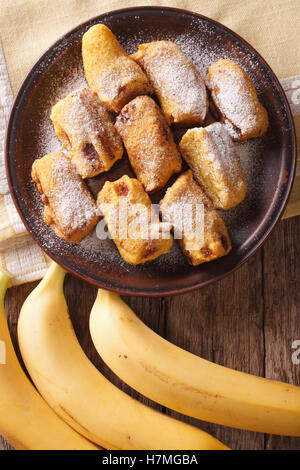 Pisang goreng bananes frites dans la pâte sur une plaque libre sur la table. Vue verticale d'en haut Banque D'Images