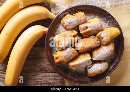 Pisang goreng bananes frites dans la pâte sur une plaque libre sur la table. Vue du dessus horizontale Banque D'Images