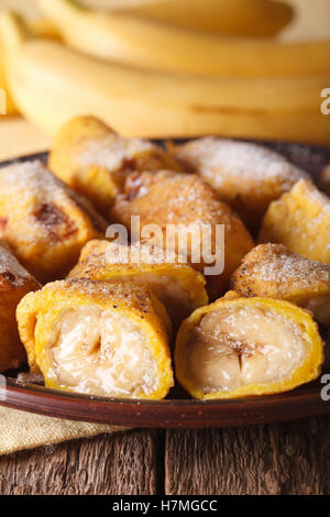 Pisang goreng bananes frites dans la pâte sur une plaque libre sur la table verticale. Banque D'Images