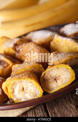 Bananes frites dans la pâte sur une plaque libre sur la table verticale. Banque D'Images