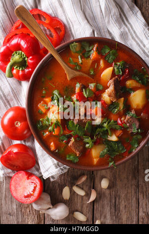 Soupe de goulash hongrois bograch close-up sur la table et d'ingrédients. Vue verticale d'en haut Banque D'Images