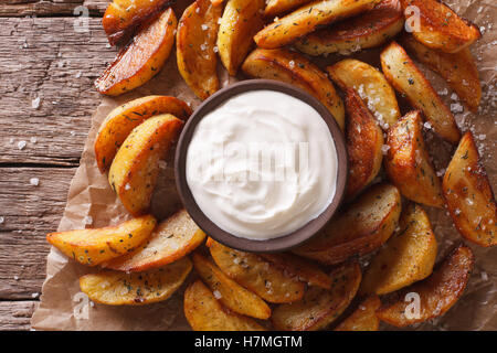 Quartiers de pommes de terre au four et de la mayonnaise sur la table horizontale vue du dessus. Banque D'Images