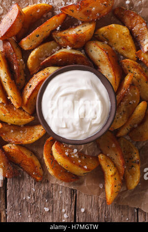Quartiers de pommes de terre au four et de la mayonnaise sur la table. Vue verticale d'en haut Banque D'Images