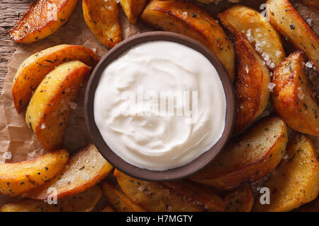 Quartiers de pommes de terre au four et de la sauce sur la table. Vue du dessus horizontale Banque D'Images