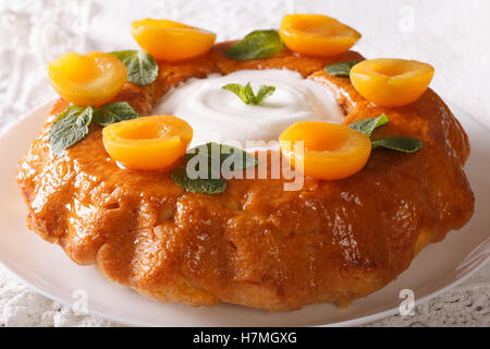 Dessert français : Savarin aux abricots et menthe close-up sur une plaque horizontale. Banque D'Images