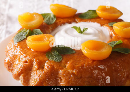 Savarin dessert français avec l'Abricot et Crème fouettée macro sur une assiette. L'horizontale Banque D'Images