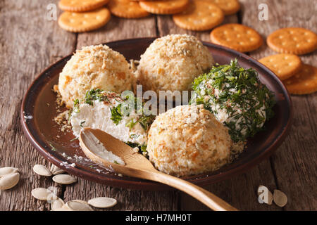 Boules de fromage cottage avec des craquelins, des herbes et graines de citrouille sur une assiette. L'horizontale Banque D'Images