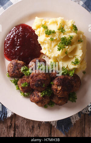 La cuisine suédoise : boulettes de viande, sauce aux airelles avec garniture de pommes de terre sur une plaque verticale. close-up Vue de dessus Banque D'Images